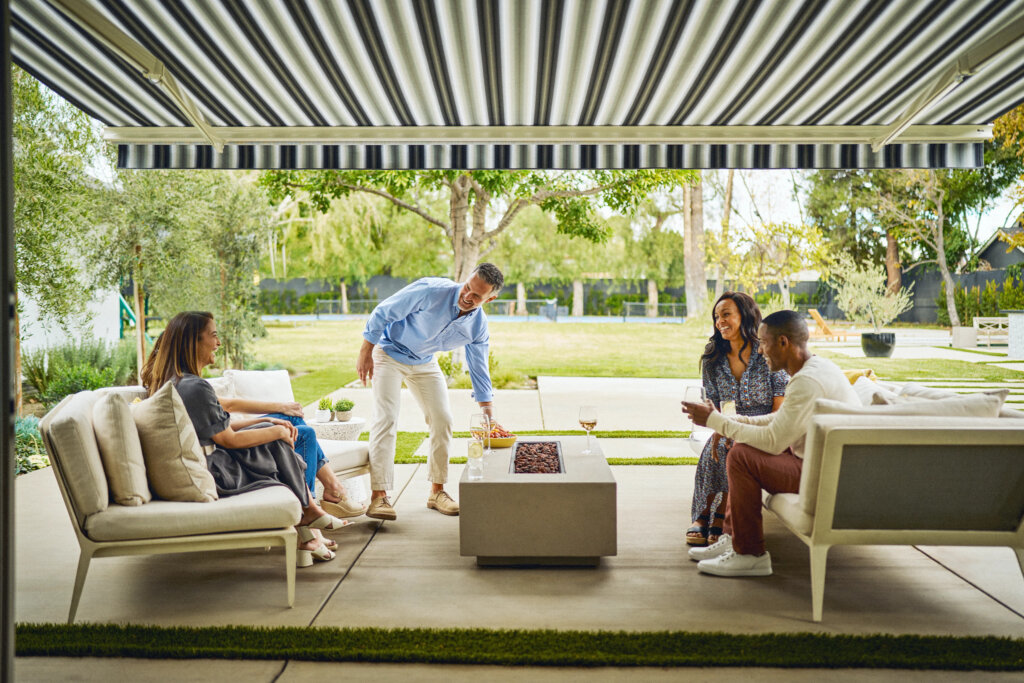 Two couples enjoying time together underneath a sunsetter awning