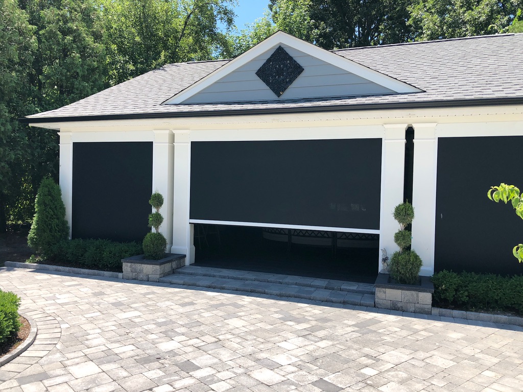 Motorized screen covering front of garage