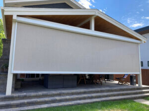 A Denver home with a solar shade installed on the outside of their covered patio for sun protection and privacy